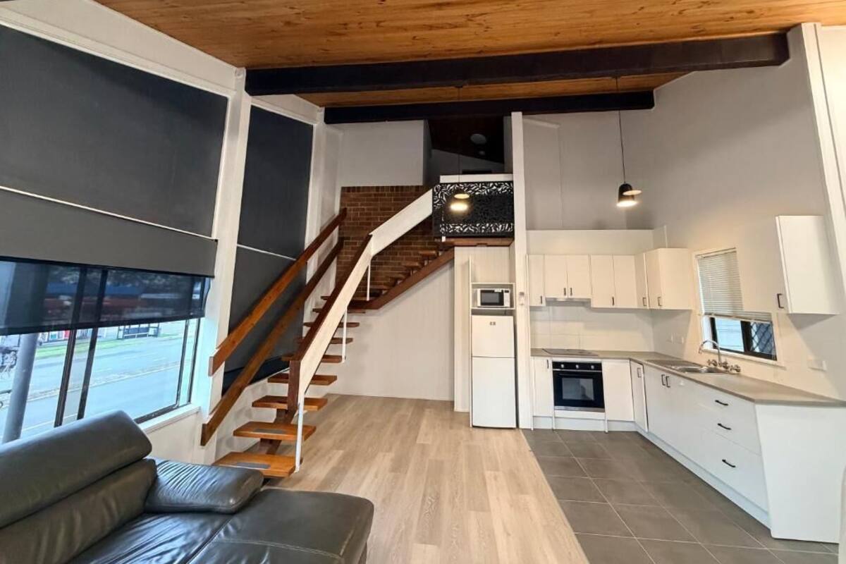 Un intérieur moderne comprenant un escalier, une cuisine et un coin salon.