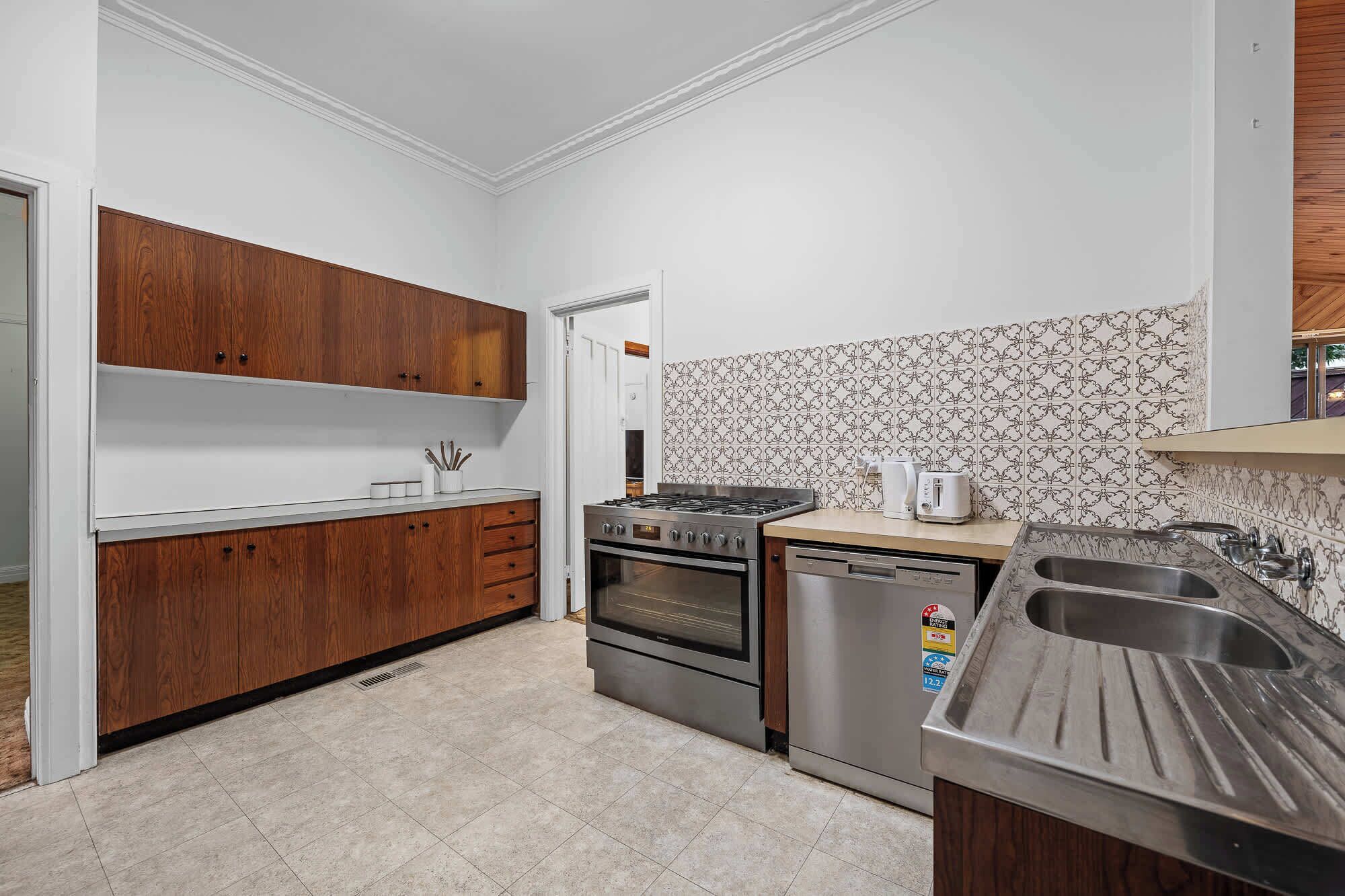A kitchen with wooden cabinets, a stove, oven, and a dishwasher.