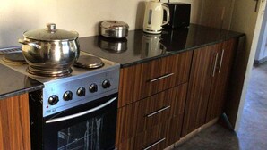 Eine kleine Küche mit Herd, Backofen und Kaffeemaschine auf der Arbeitsfläche.