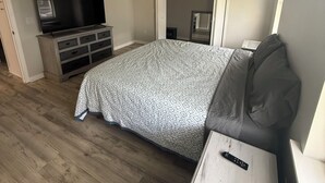 A bedroom with a bed, a TV, a dresser, and a ceiling fan. - 2-bedroom house in the villages with golf course view and included golf cart! (Lady Lake)