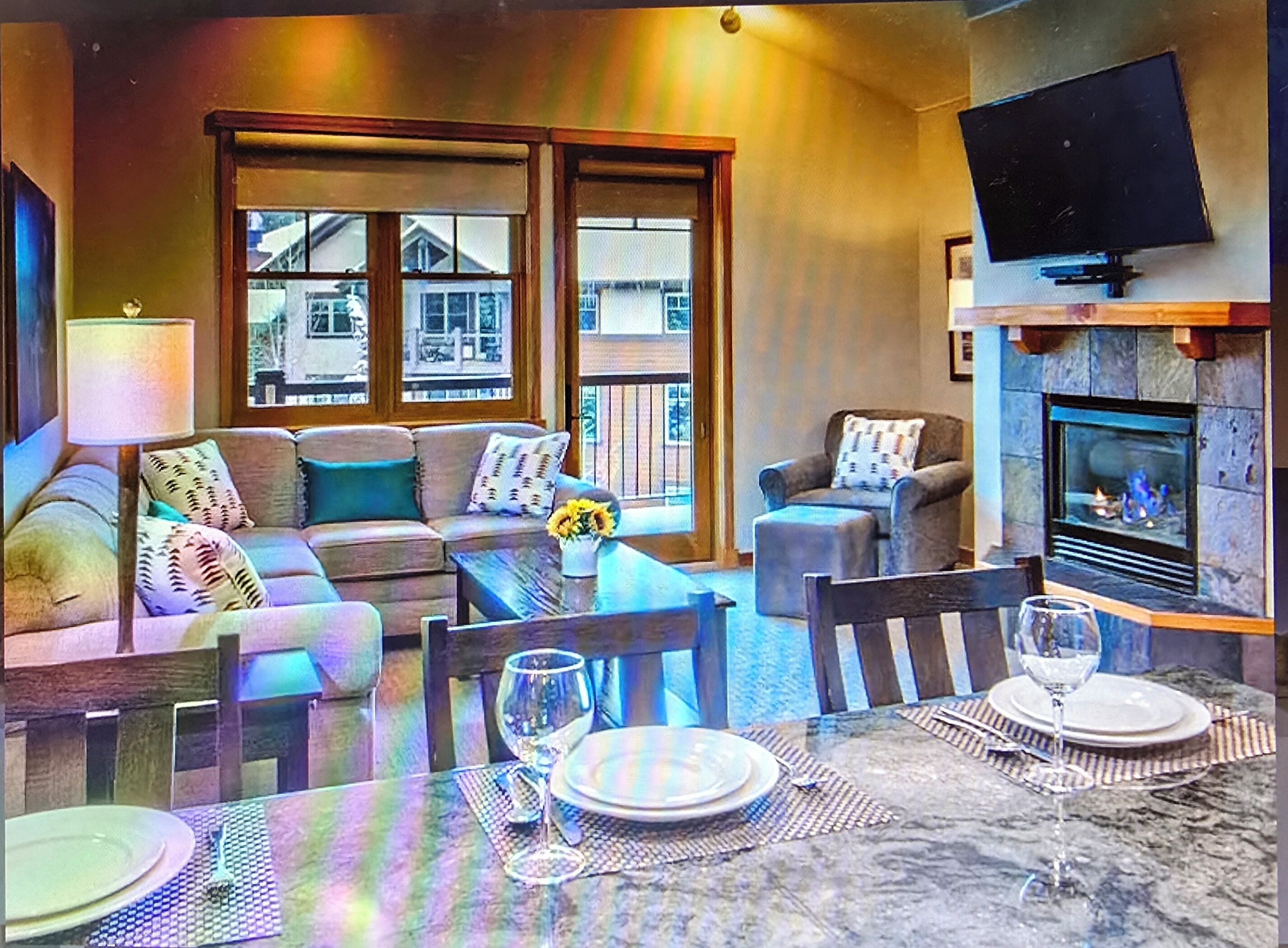 Ein gemütliches Wohnzimmer mit einer Couch, Sesseln, einem Couchtisch und einem Kamin.