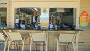 A bar with a counter, chairs, and a menu board. - Island Links - 3BR/2BA - Great Pool Complex! (Hilton Head Island)