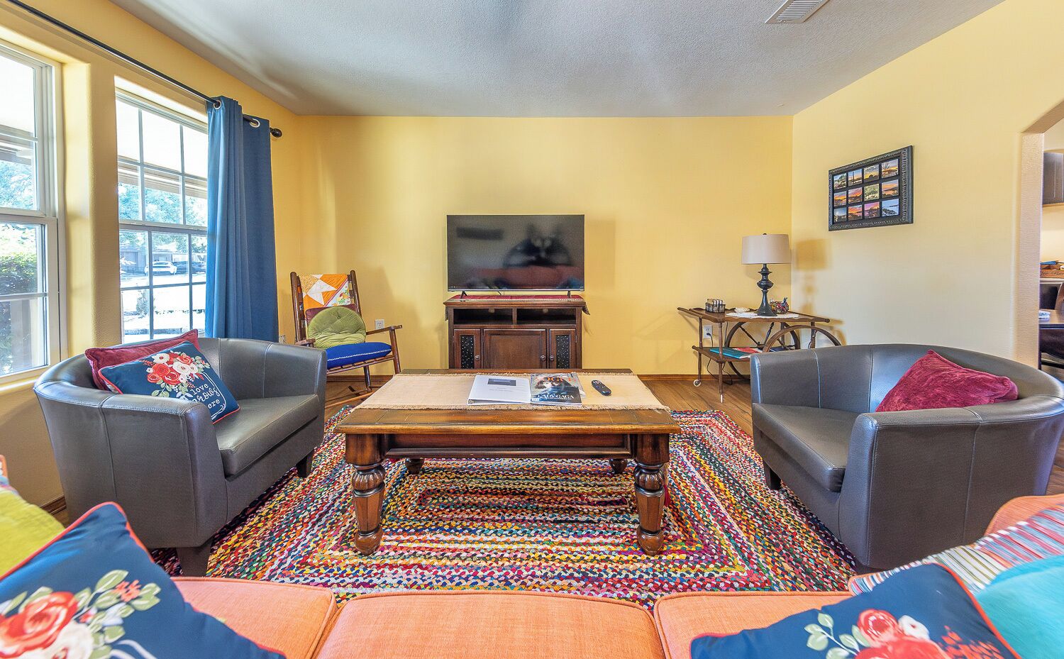 Una sala de estar con dos sillones de cuero, una mesa de centro de madera y una alfombra colorida.