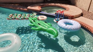 Una piscina con giochi gonfiabili, tra cui un giubotto a forma di coccodrillo e degli anelli.