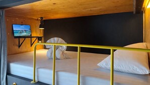 A bunk bed with a TV on the left, a yellow railing, and a towel draped over the headboard. - Free Way Kata Beach Hostel (Karon)