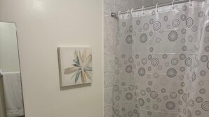 A bathroom with a toilet, sink, and shower curtain.