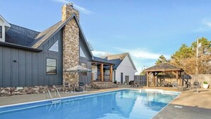 Il s’agit d’une propriété résidentielle dotée d’une piscine, d’une cheminée en pierre et d’un patio couvert.