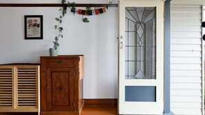 Una habitación con un aparador de madera, un vidrio con diseño geométrico y un letrero en la pared.