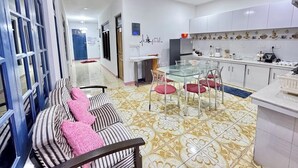 Una cucina moderna con mobili bianchi, un tavolo da pranzo in vetro e un pavimento decorato.