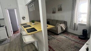 A modern apartment with a dining area, kitchen, and living space.