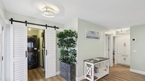 A laundry room with a washing machine, a drying rack, and a large potted plant. - Tee to Sea Retreat - Inside TPC Sawgrass Gated Community, Ponte Vedra Beach  (Palm Valley)