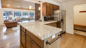 Eine geräumige Küche mit Granit-Arbeitsplatten, Holzschränken und einem Edelstahl-Kühlschrank.