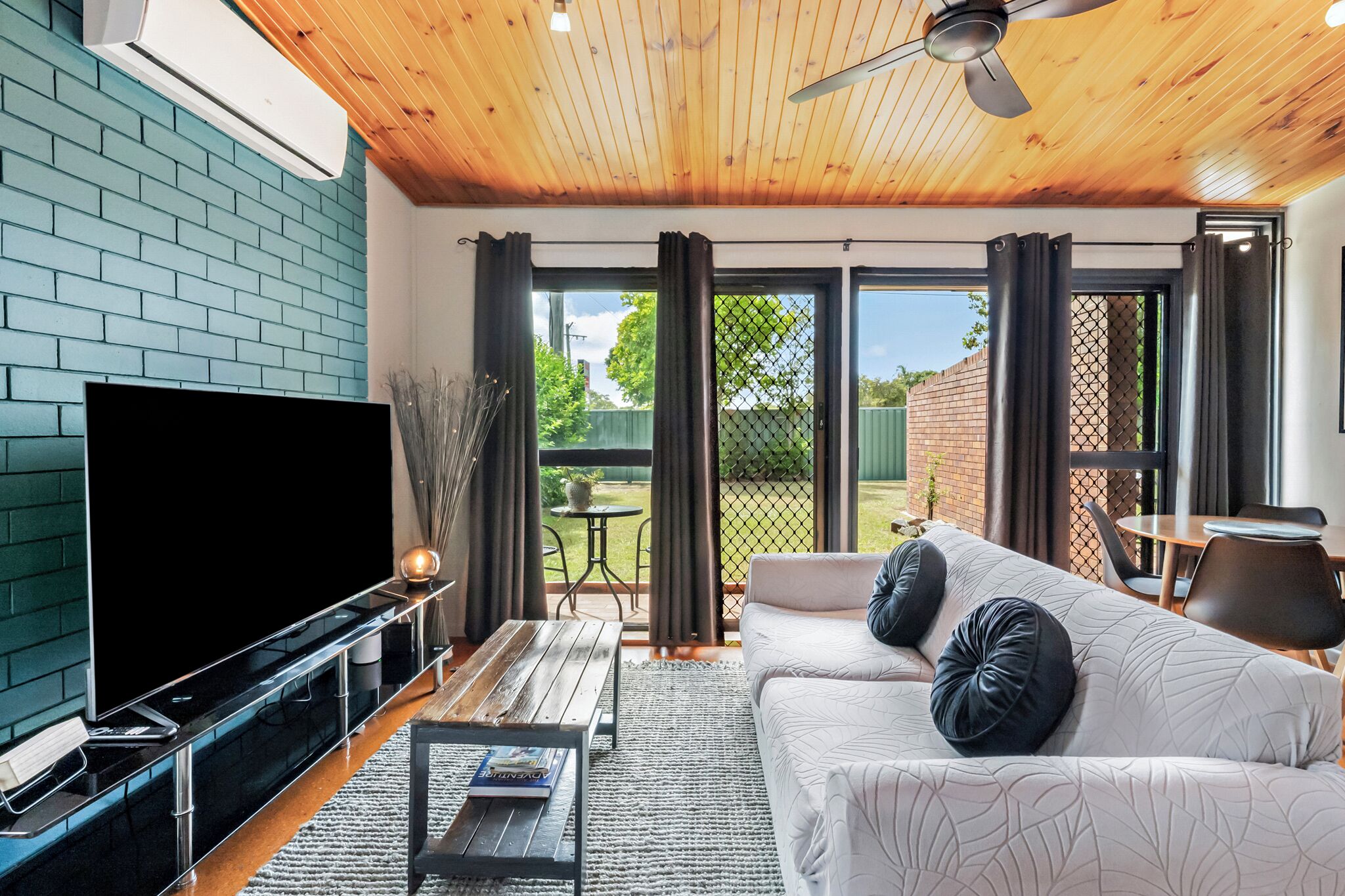 Comfortable lounge with smart TV, A/C, natural light, and relaxing space.