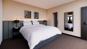 Una habitación de hotel con una cama grande, una mesita de noche, una lámpara y dos cuadros colgados en la pared.
