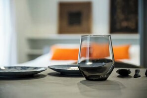 Een tafel met een glas rode wijn, borden en bestek in een moderne hotelkamer.
