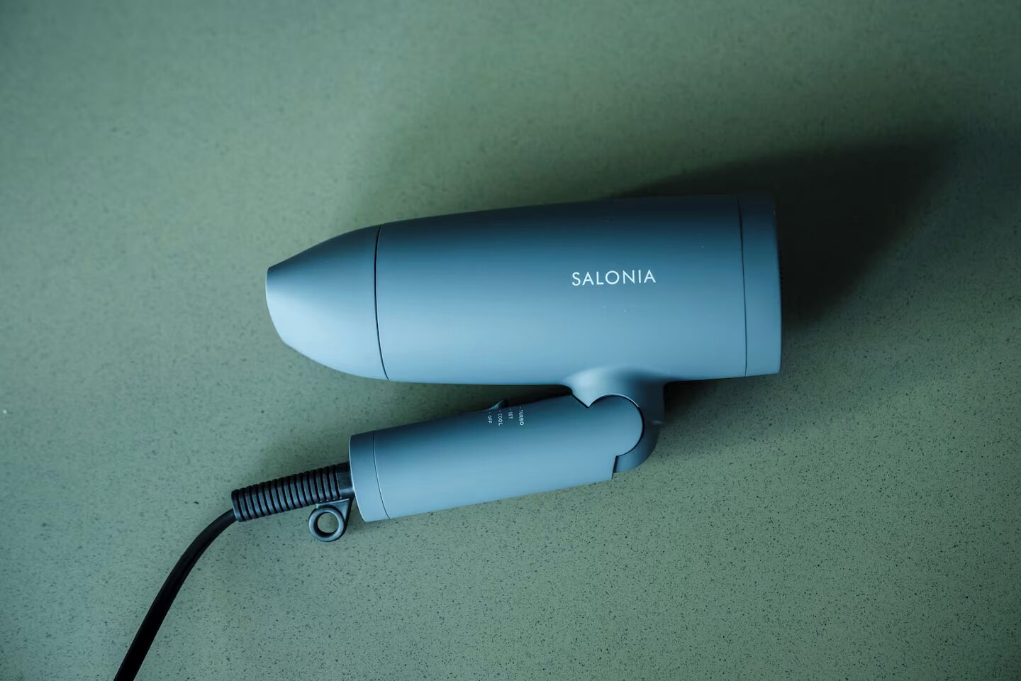 A hair styling tool with the brand name SALONIA on a countertop.