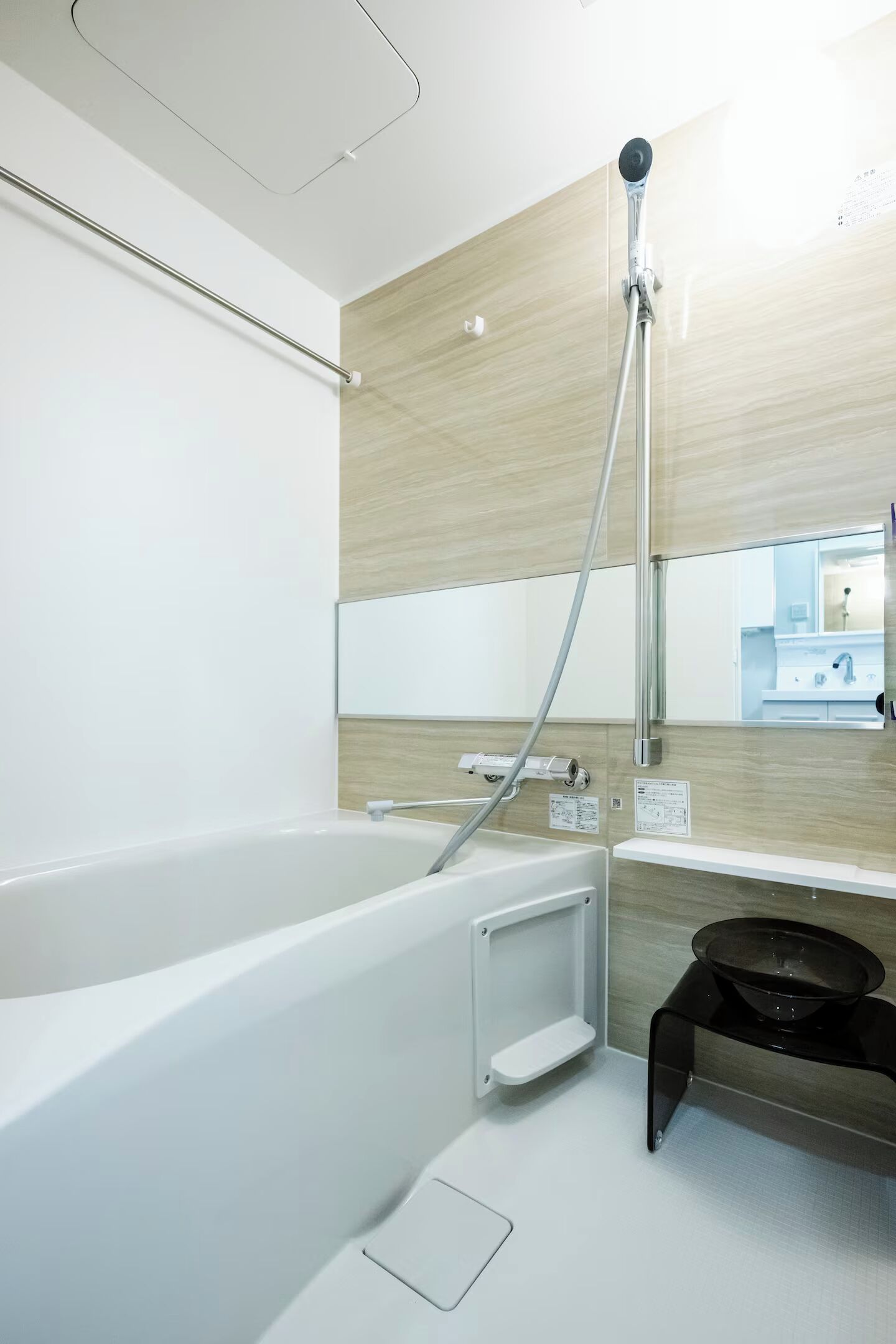 A modern bathroom with a bathtub, a showerhead, a sink, and a mirror.