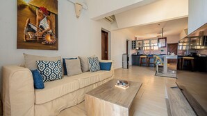 A living room with a sofa, coffee table, and a painting on the wall. - Diani Beachfront Paradise (Diani Beach)