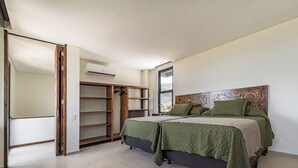 Un dormitorio con cama, armario y aire acondicionado.