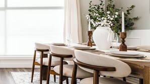 A dining table set with plates, glasses, and a candle holder. - Luxury 3BR Retreat Near Downtown | 5-PC King Ensuite +Private Balcony | Sleeps 6 (Calgary)