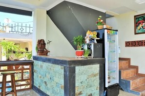 A kitchen with a counter, refrigerator, and potted plants. - D' Artha Cottage (Bali)