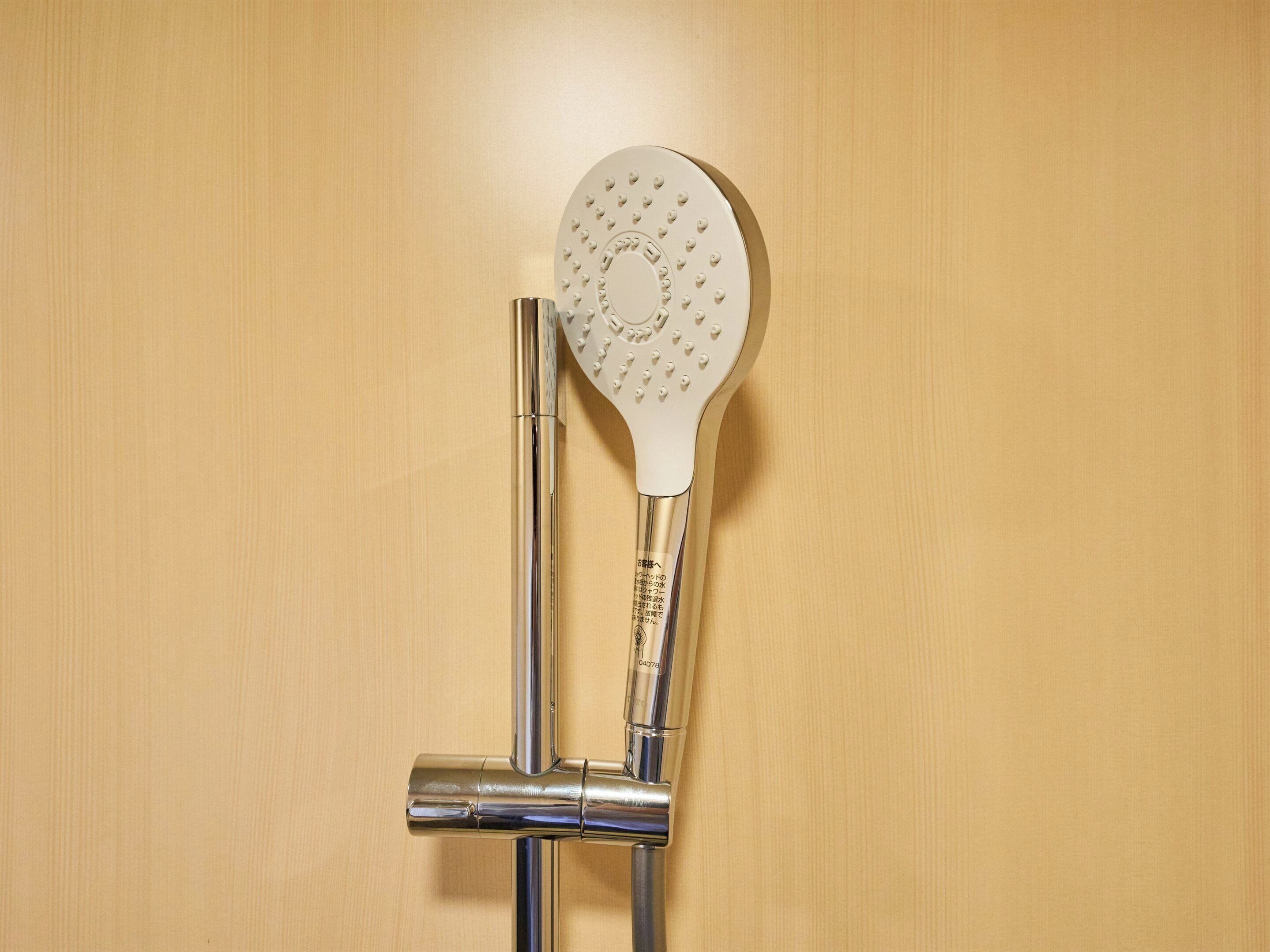 A showerhead with a circular design and a control valve.