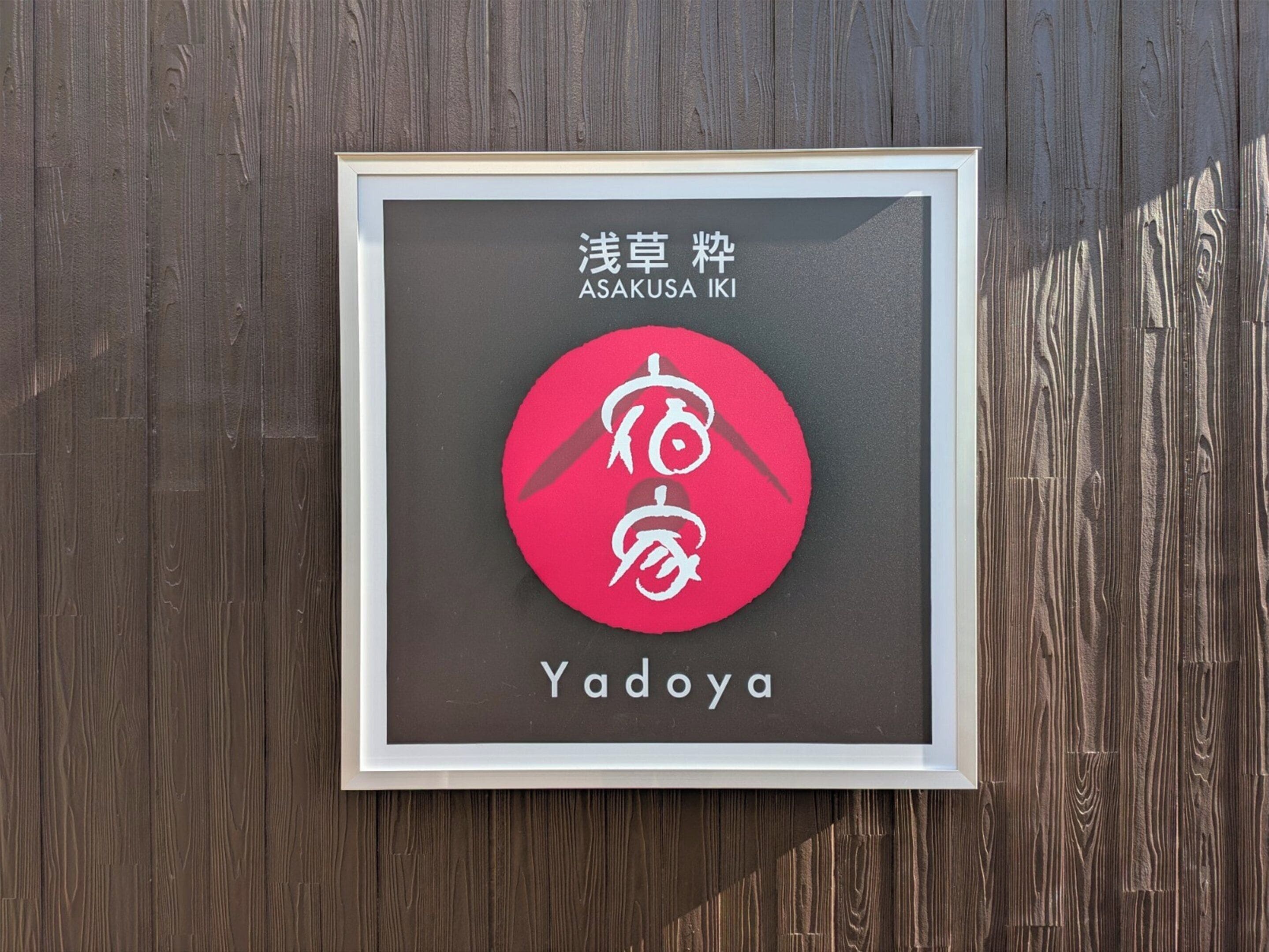 A framed sign with Japanese text and a red circle with white characters.
