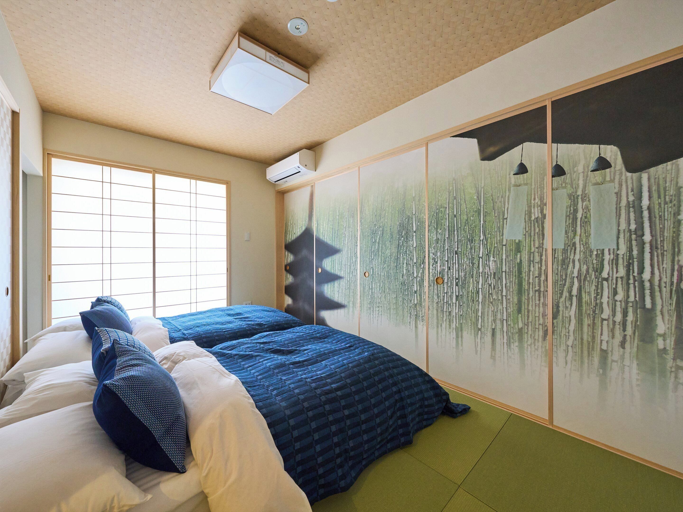 Un dormitorio con una cama grande, un divisor japonés corredero y un ventilador de techo.