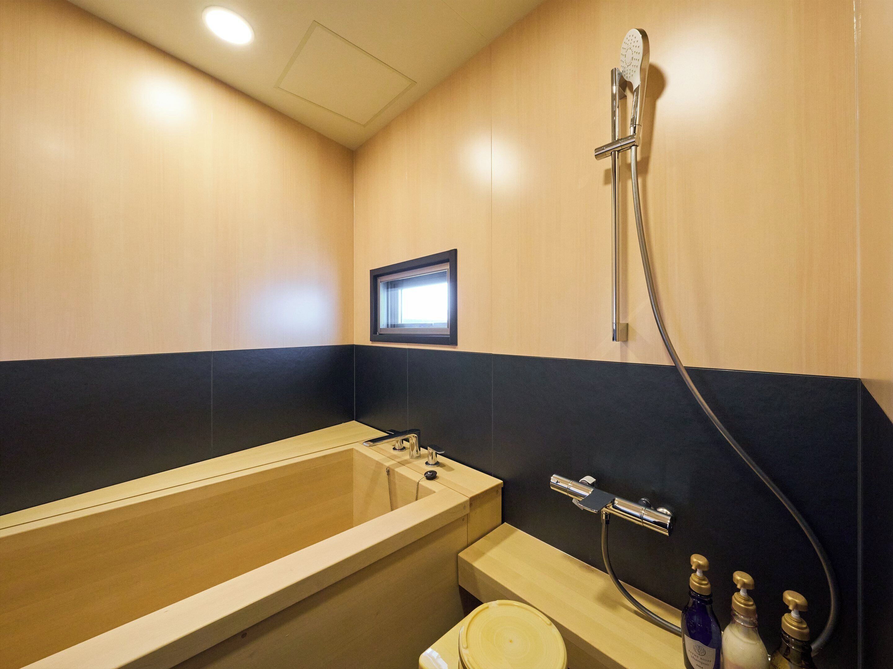 A modern bathroom with a bathtub, a shower, and a toilet.