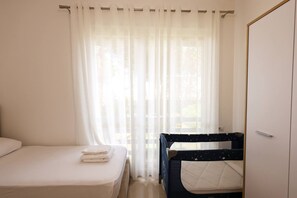 Een slaapkamer met een enkel bed, een slaapplein en een kledingkast.