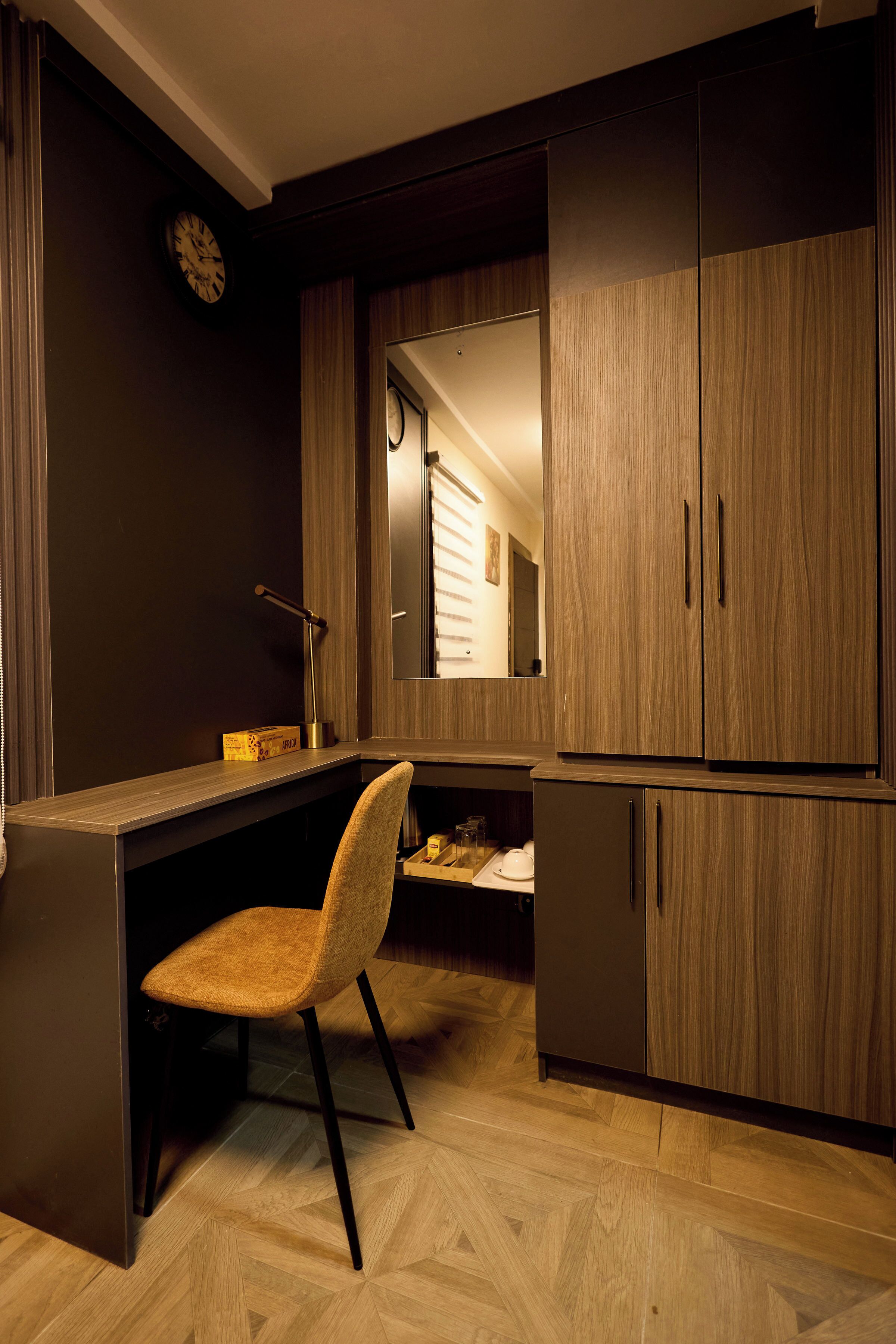 Une cuisine moderne avec un parquet en bois disposé en motif chevron, un bureau intégré et une chaise.