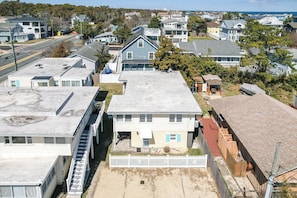A residential area with a mix of single and multi-story houses, a visible road, and a clear sky.