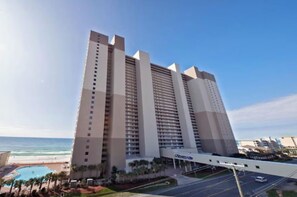 Un grand hôtel à plusieurs étages, doté d’une piscine et offrant une vue sur la plage.