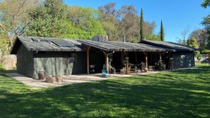 Una casa moderna con patio coperto, pannelli solari e un prato curato.