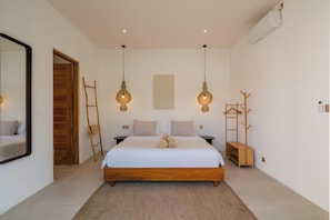 A bedroom with a wooden bed, two bedside tables, a ladder, a coat rack, and a large mirror. - Lumi Villa by Betterplace (Pecatu)