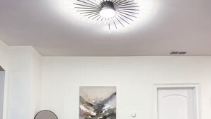 A modern dining area with a glass table, leather chairs, a potted plant, a contemporary ceiling light, and a minimalist wall art piece. - Spacious 6 bed 2 bath suburban escape 20 min from downtown Chicago (Blue Island)