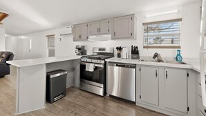 Een moderne keuken met roestvrijstalen apparatuur, witte kasten en een inbouwvaatwasser.