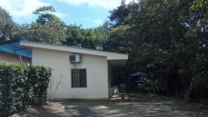 A single-story building with a flat roof, a small window, and an air conditioning unit.