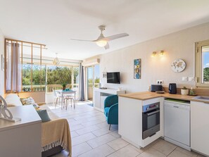 Une cuisine moderne équipée d’un four encastré, d’un lave-vaisselle et d’un coin repas avec une table et des chaises.