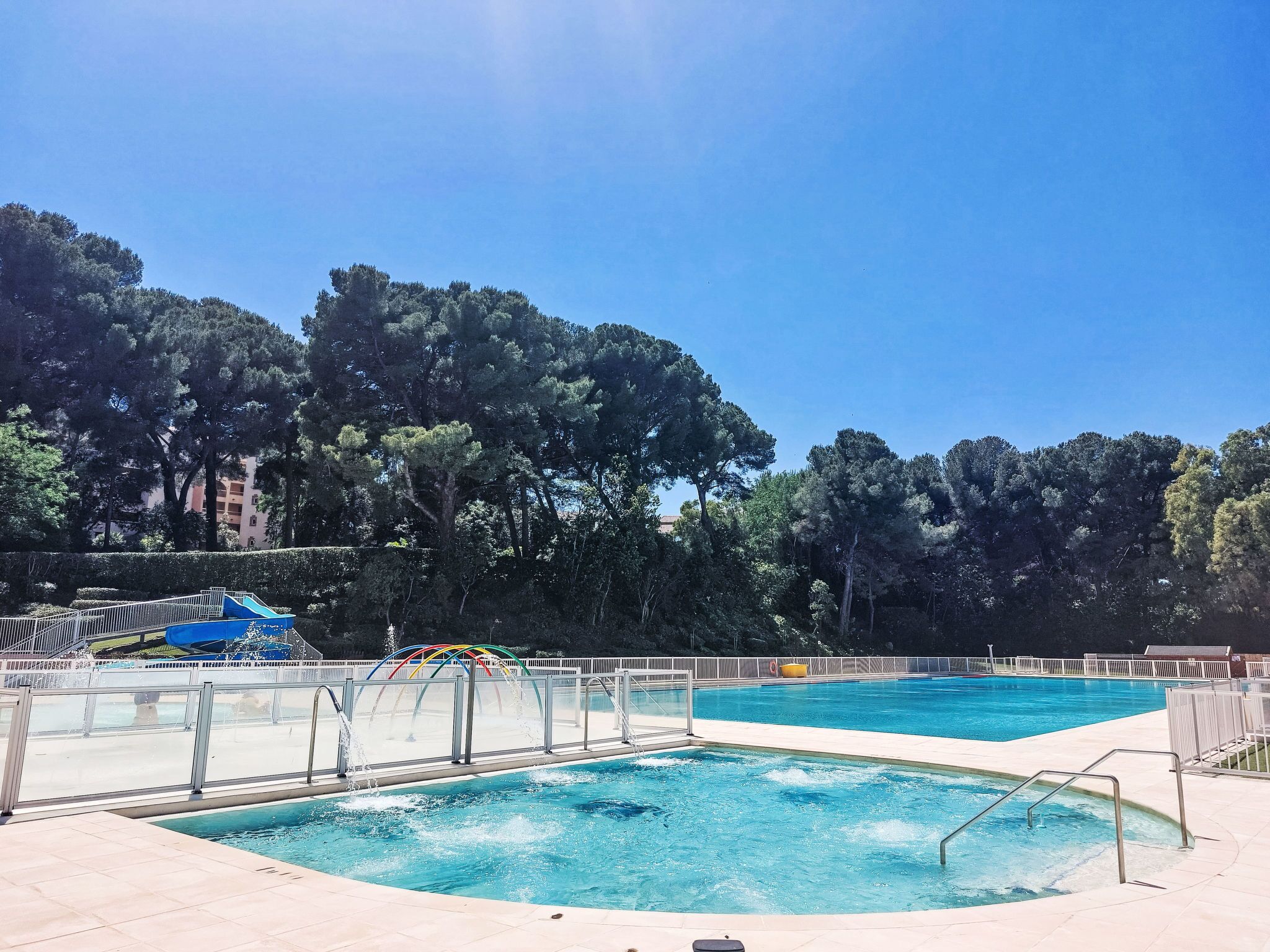 Une piscine avec un toboggan et un espace piscine séparé.