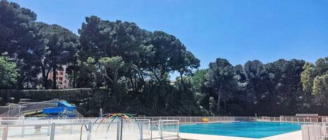 Une piscine avec un toboggan et un espace piscine séparé.