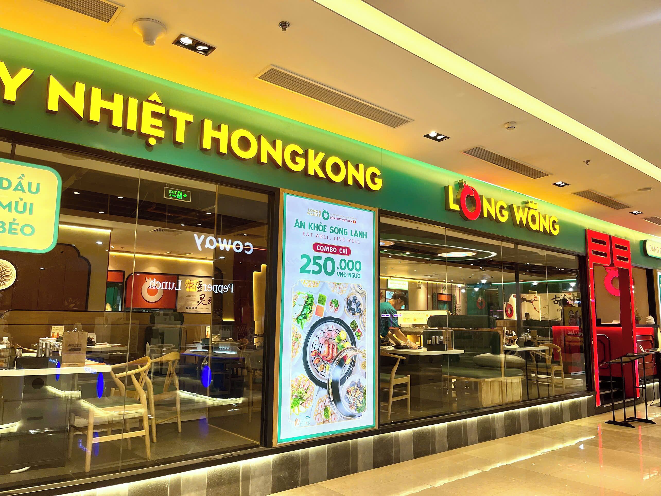 A restaurant with a green and yellow sign, a large poster advertising a 250,000 VND offer, and a visible entrance.
