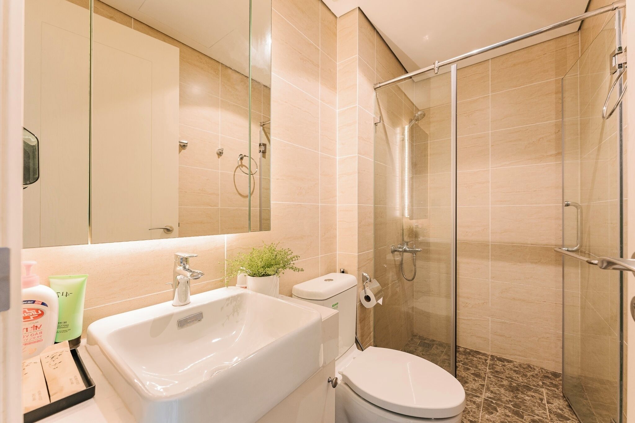 Un baño moderno con bañera, inodoro y ducha envuelta en vidrio.