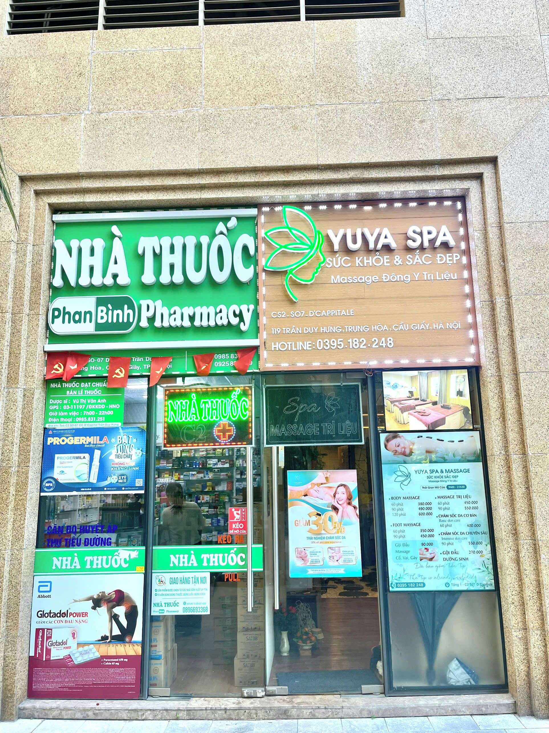Une pharmacie et un centre de bien-être dotés d’une signalétique bien visible et de panneaux publicitaires.