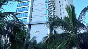 A tall, modern building with a prominent 'C5' sign at the base, surrounded by palm trees. - Hopo Apt - Vinhomes D'capitale Luxury (Hanoi)