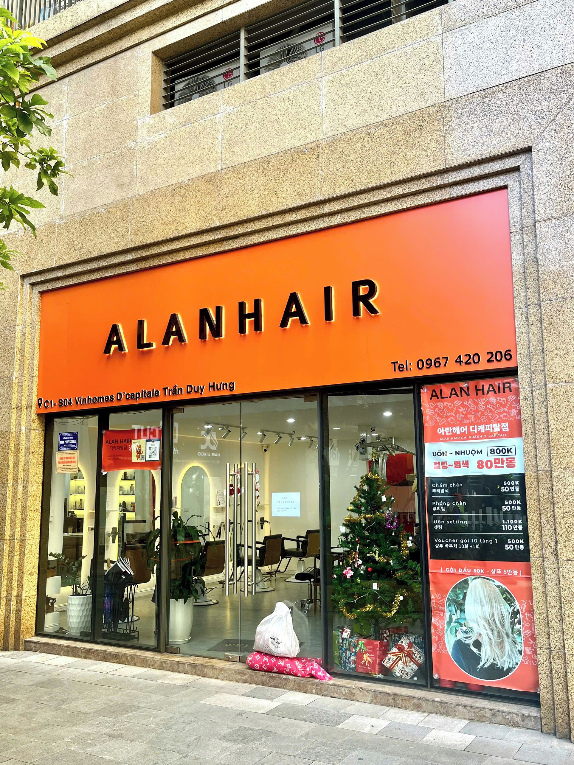Un salon de coiffure nommé « ALANHAIR », avec un numéro de téléphone et une décoration de Noël.
