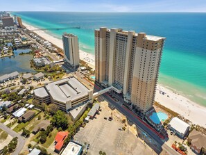 Ein Hochhaus-Hotel mit Blick auf den Strand, einem Parkplatz und einem Pier im Hintergrund.