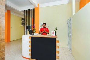 Una recepción con mostrador de madera, un teléfono y un cartel.