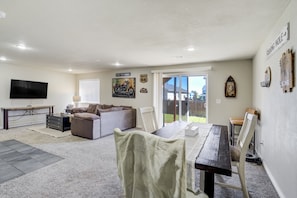 A spacious living area with a dining table, sofa, and a television. - 1415 Legend Oak - Basement (Fountain)