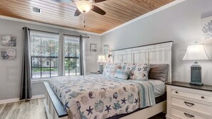 A bedroom with a bed, nightstands, a ceiling fan, and a window with blinds. - 2113 Talbot Ct (Fernandina Beach)